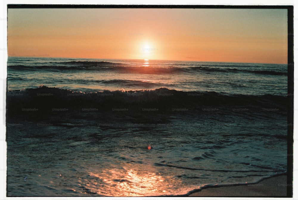 o sol está se pondo sobre as ondas do mar
