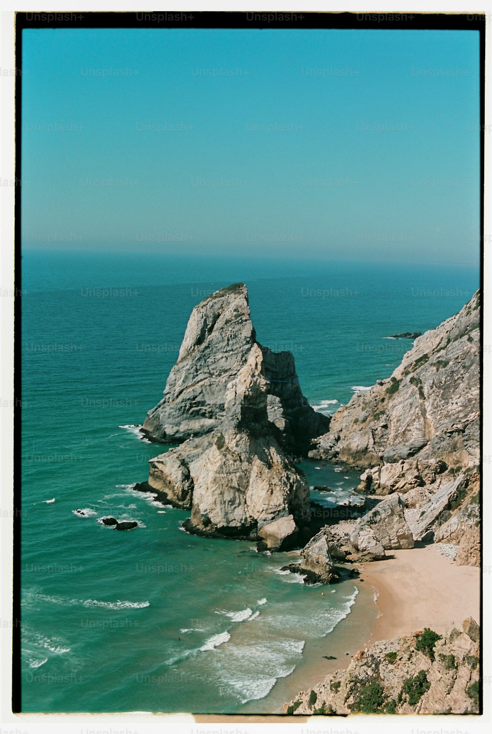 a view of a beach with a rock outcropping