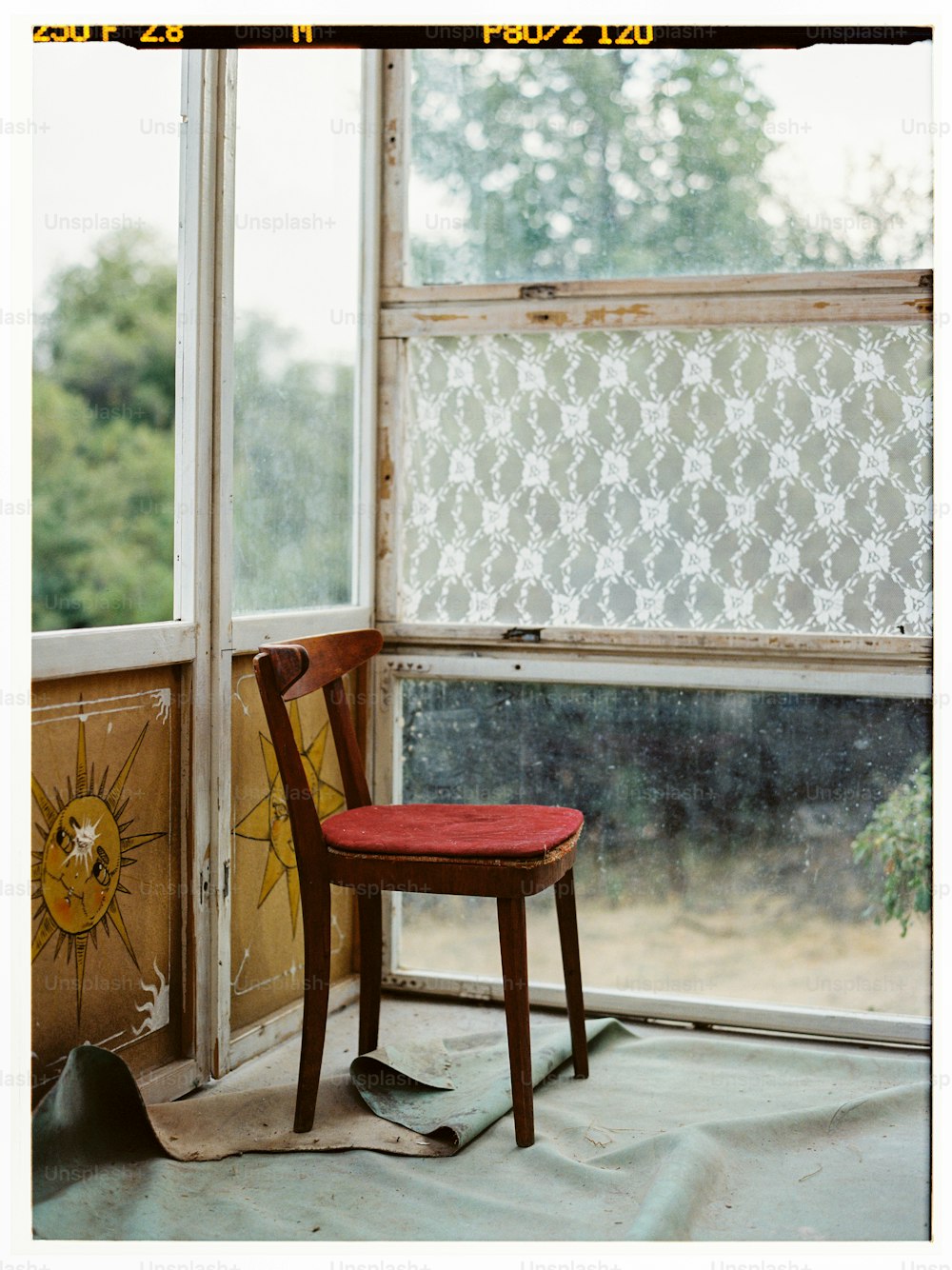 ein Holzstuhl, der vor einem Fenster sitzt