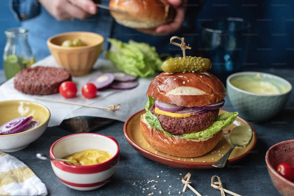 un hamburger seduto sopra un piatto accanto a ciotole di cibo