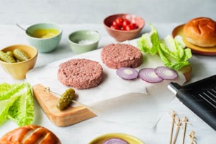 a table topped with hamburgers and other foods