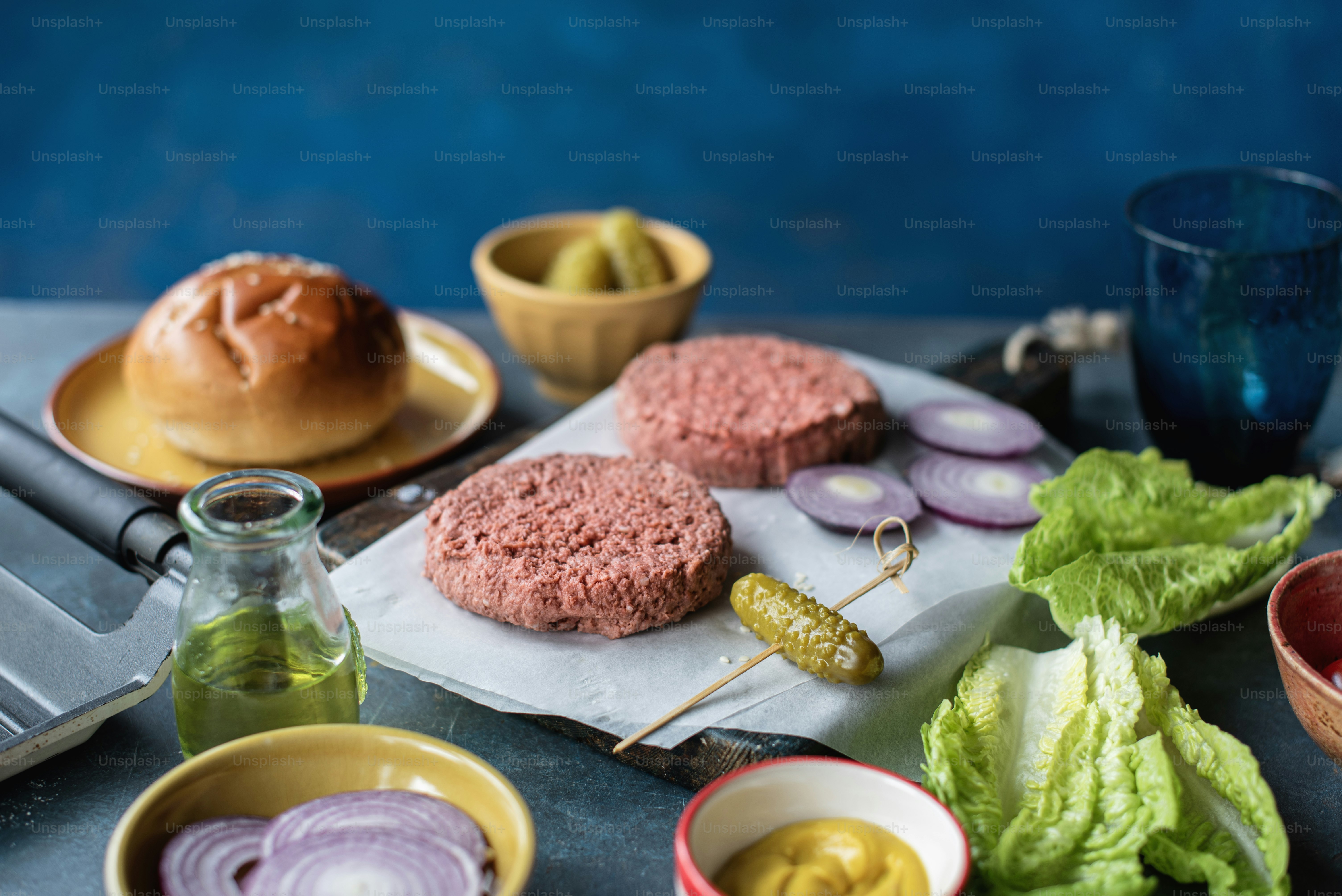 A table topped with hamburgers and other foods photo – Health Image on ...