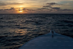 Il sole sta tramontando sull'oceano visto da una barca