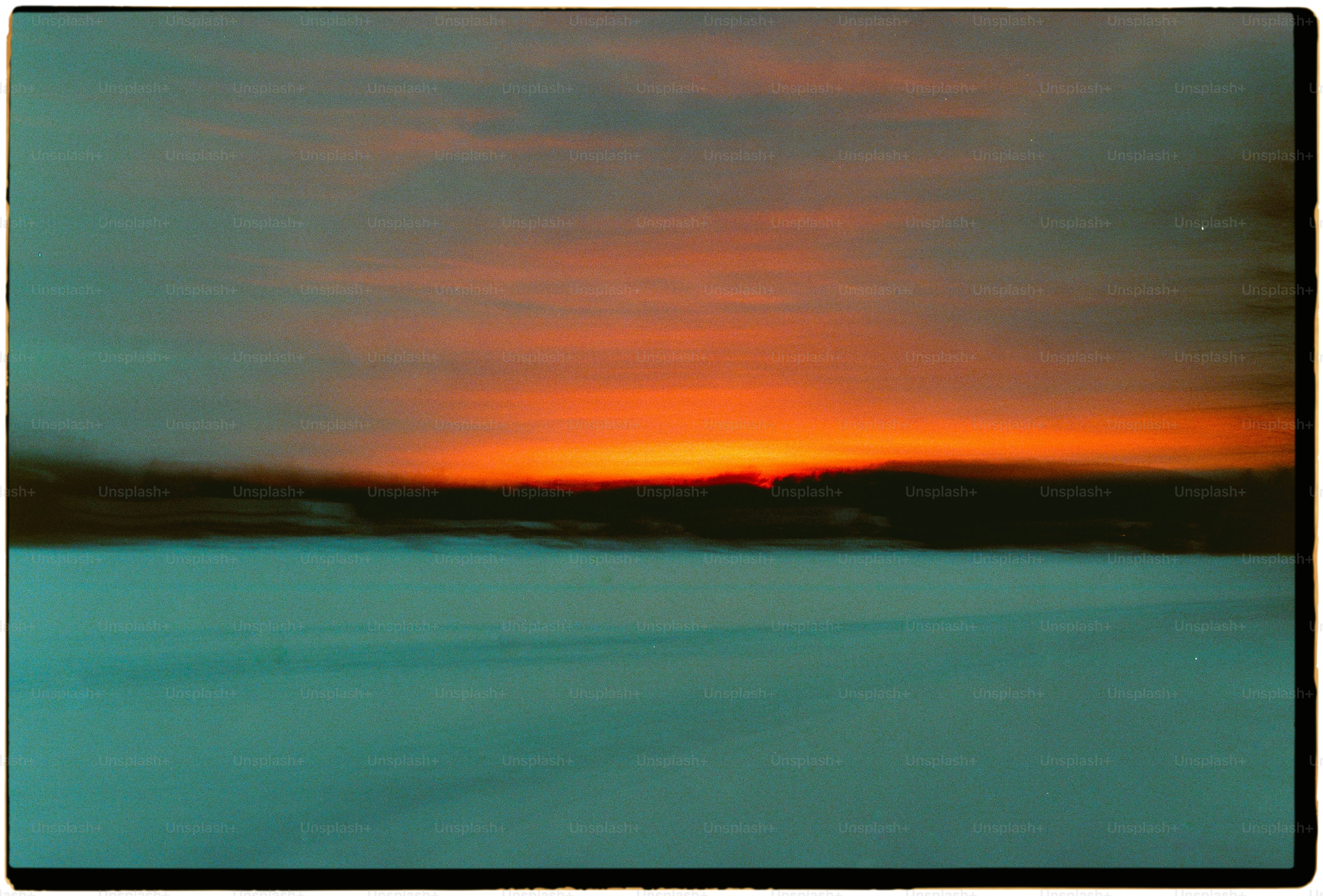 the sun is setting over a snowy field