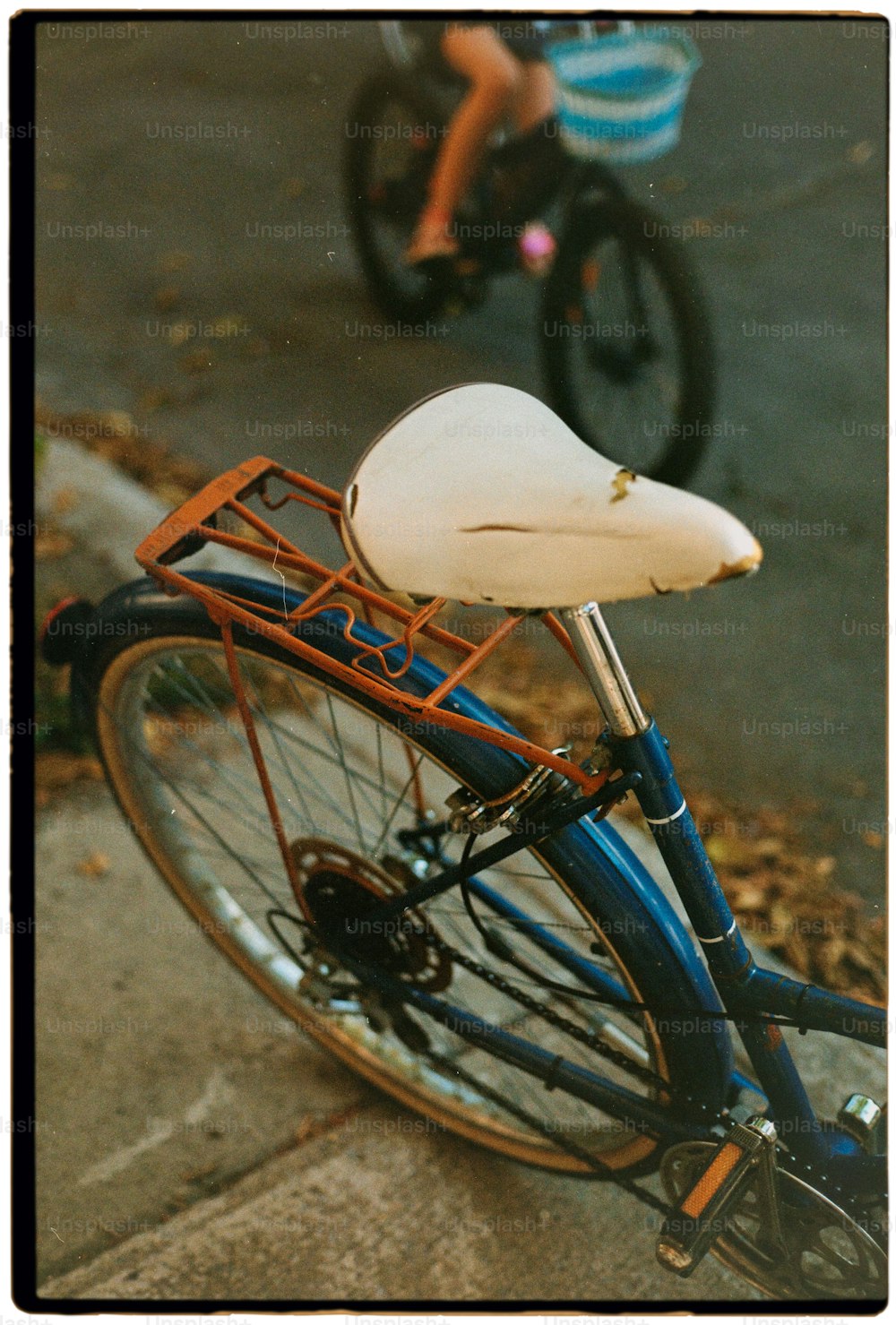 a blue bike with a white seat on the street