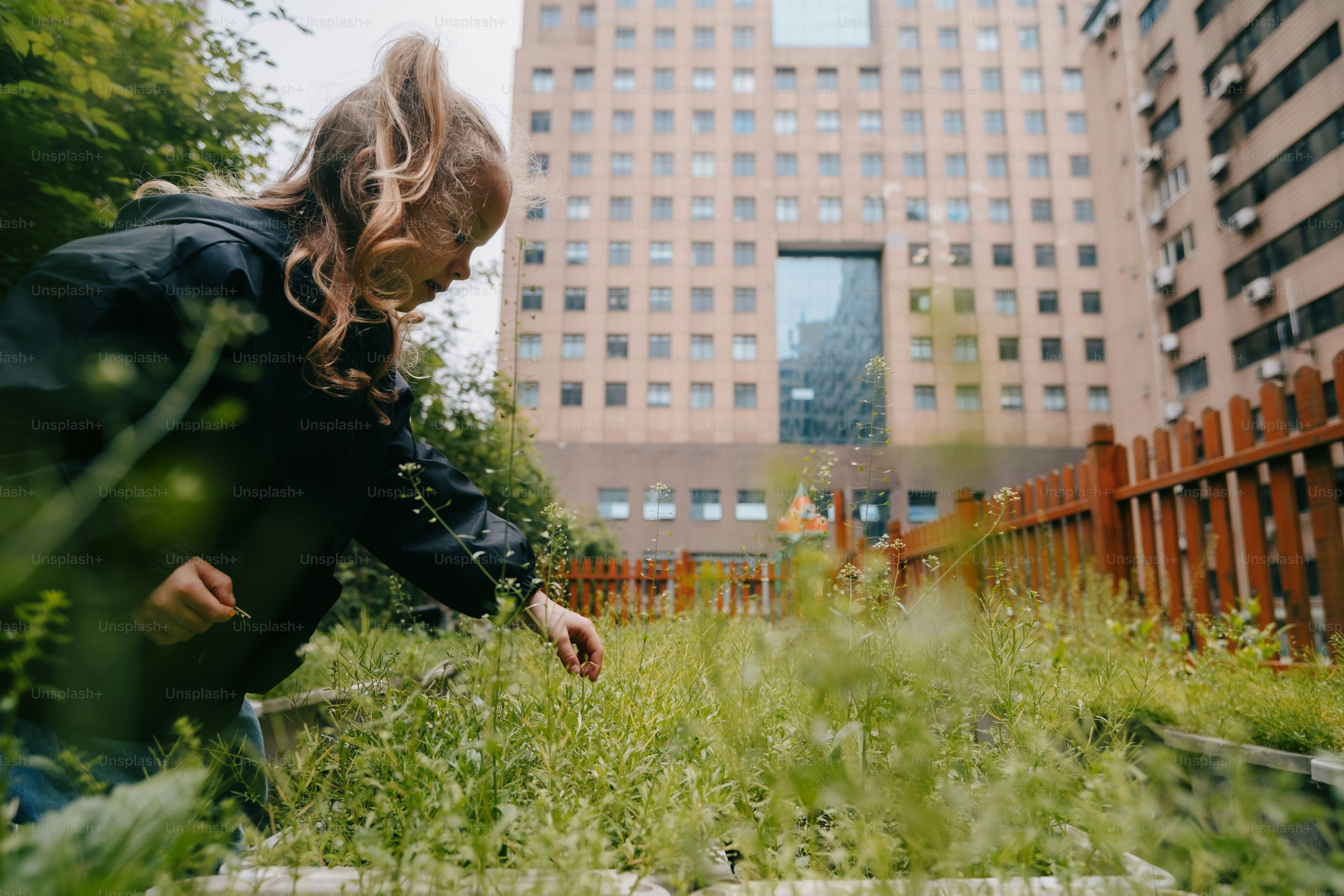 a woman kneeling down in a field of tall grass