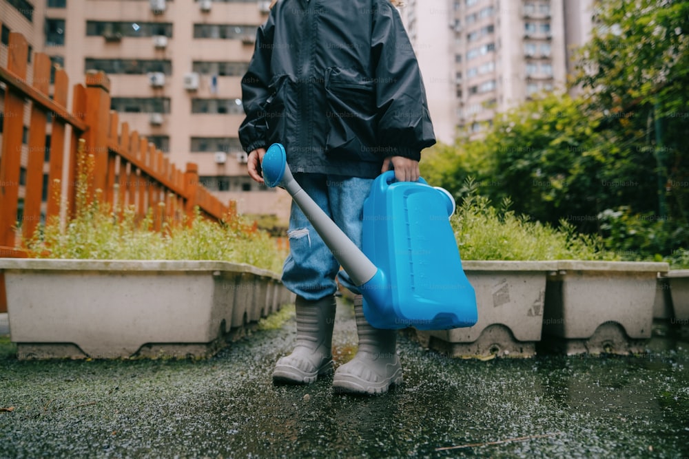 a person holding a blue suitcase and a blue handle