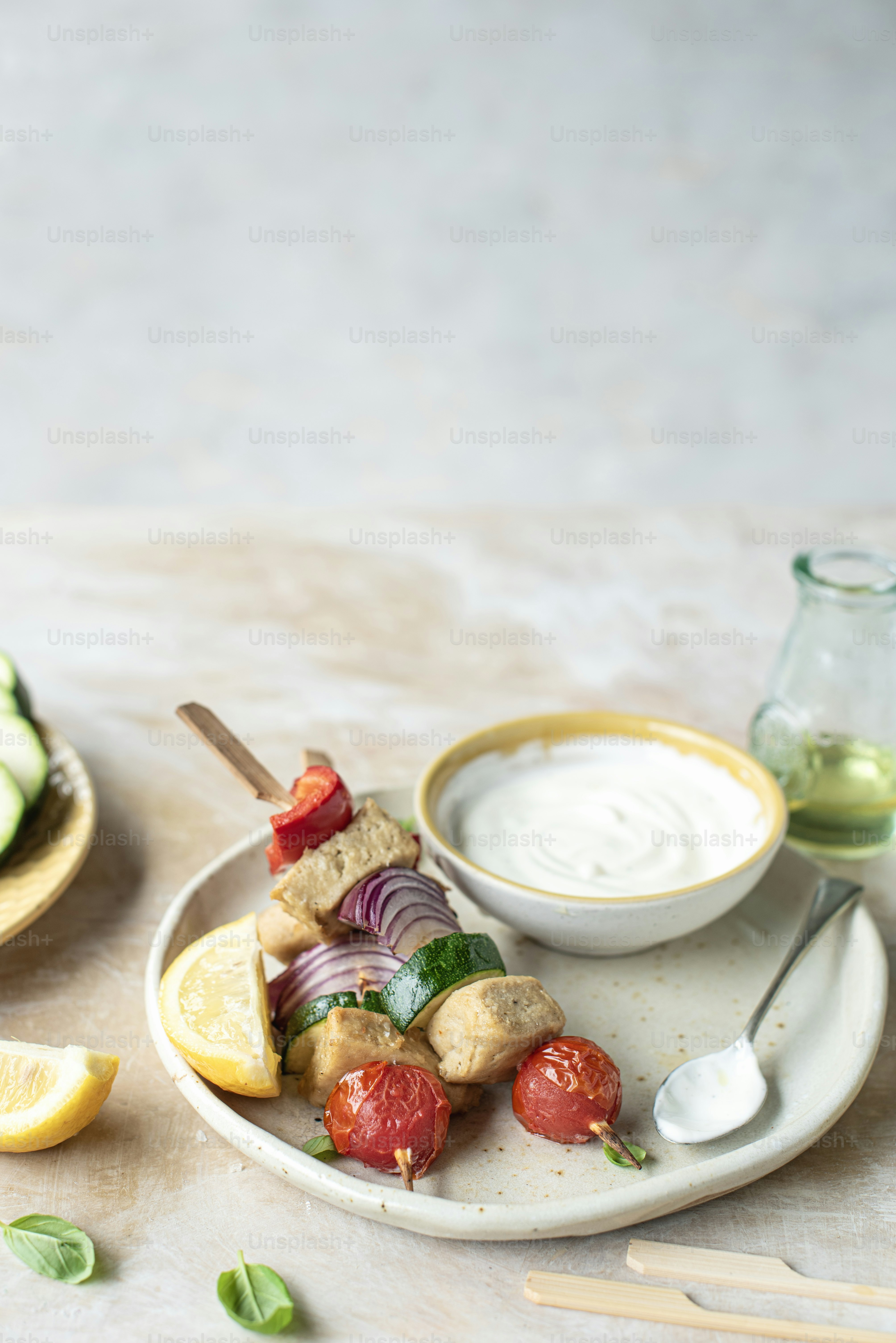a white plate topped with food next to a bowl of sauce