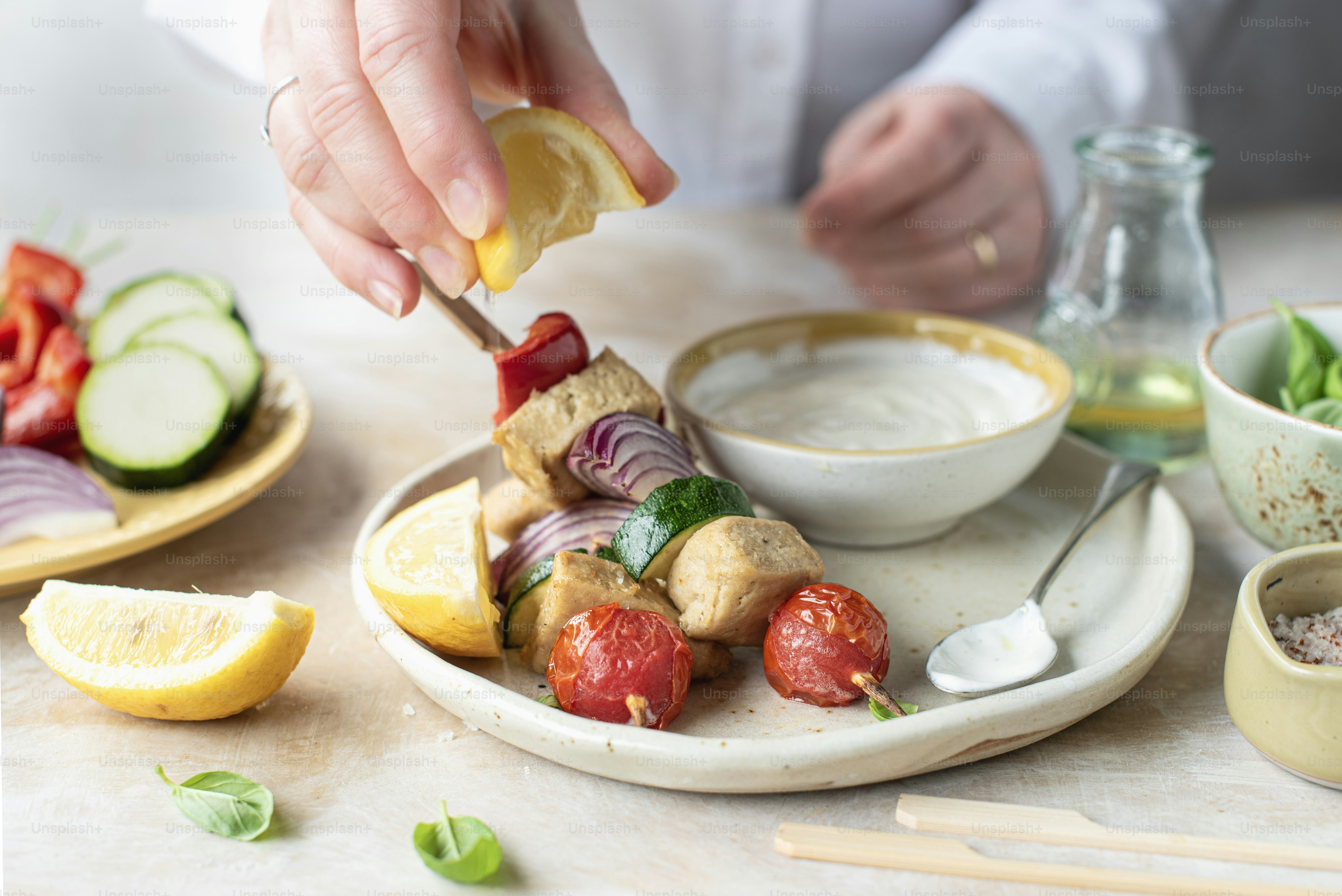 a person holding a piece of food over a plate of food
