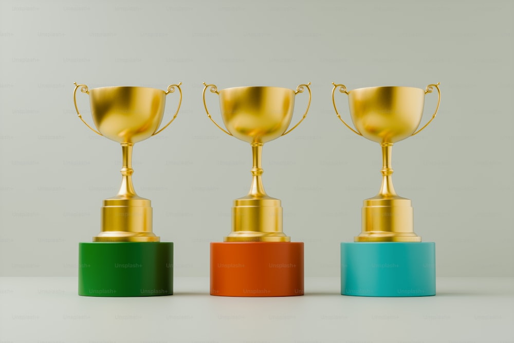 a row of three gold trophy cups sitting on top of each other
