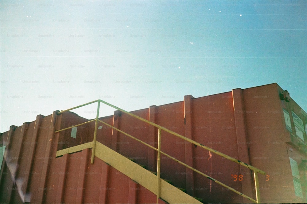 a red building with a yellow hand rail