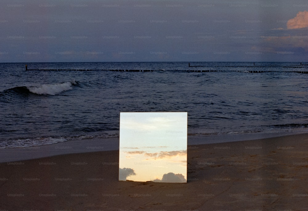 um porta-retrato sentado em cima de uma praia de areia