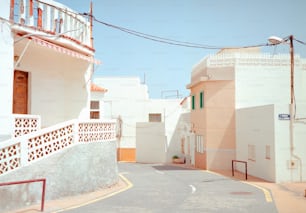 a narrow street with white buildings and a red fire hydrant