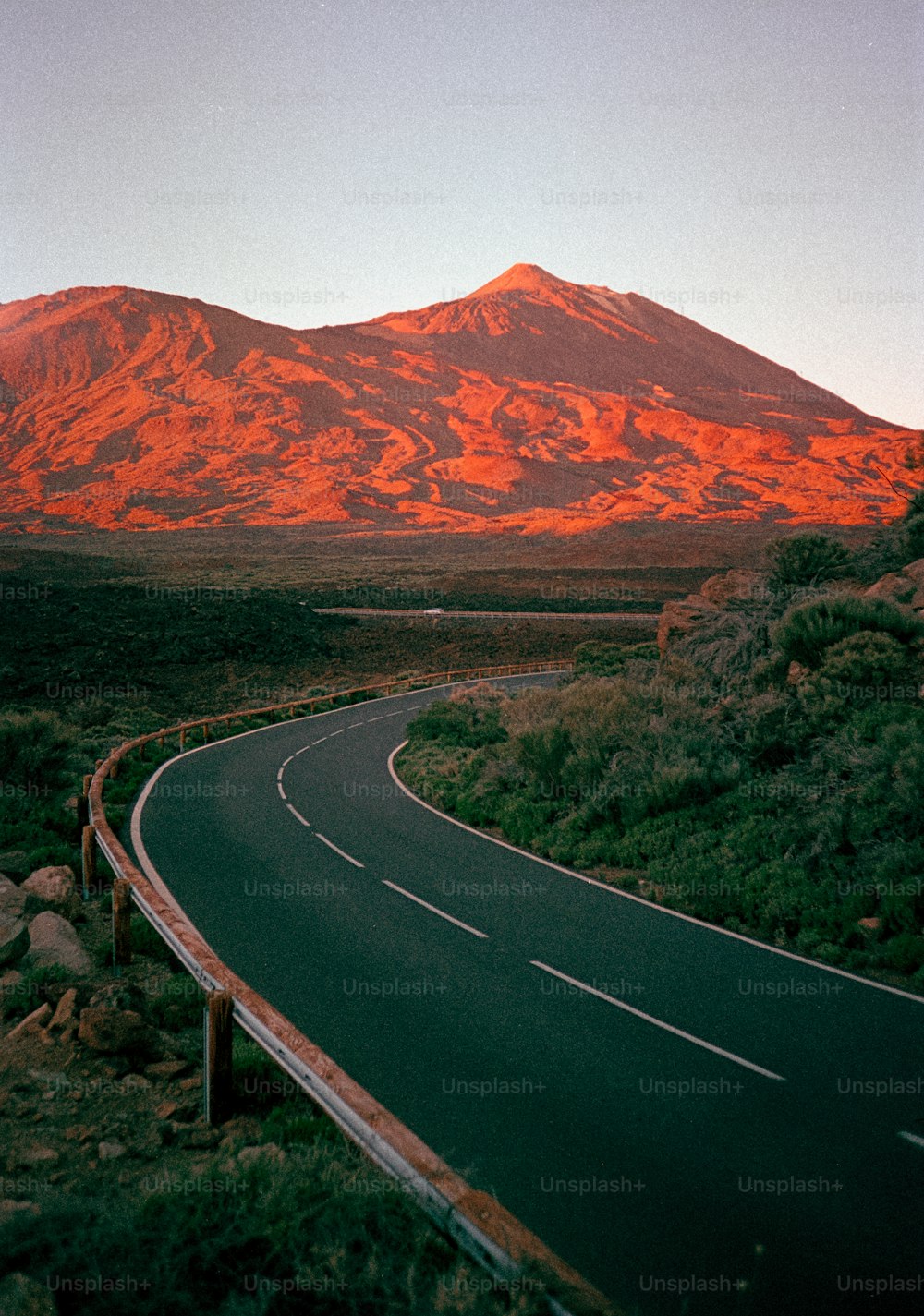 a winding road with a mountain in the background