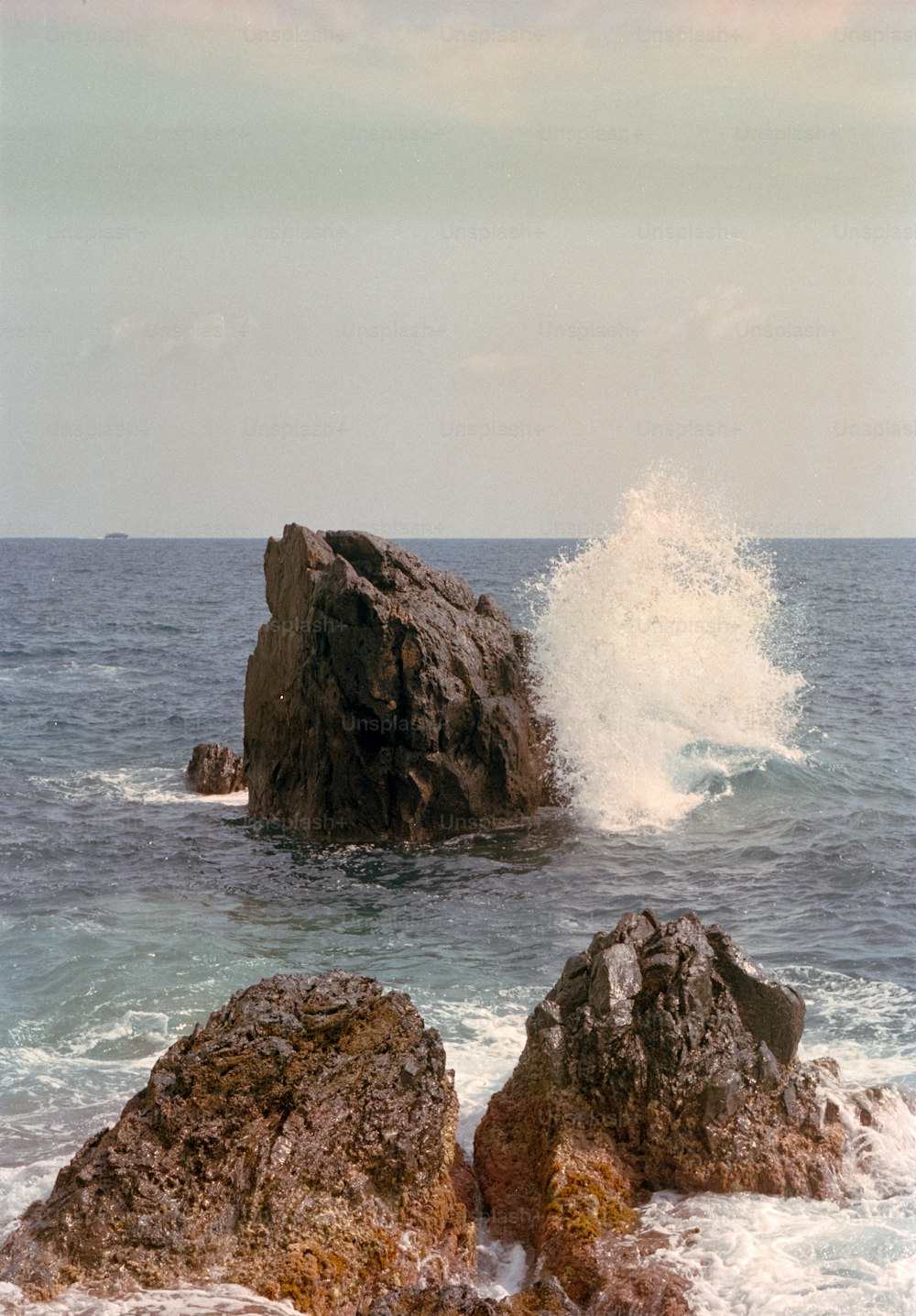 a large rock in the middle of the ocean