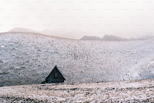 una colina cubierta de nieve con una casa en la cima
