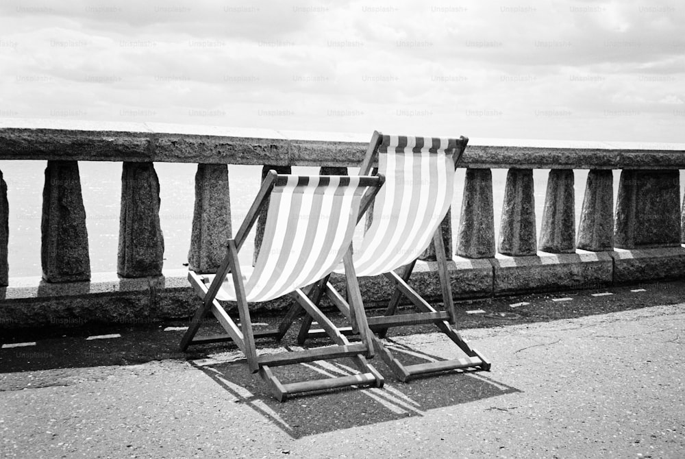 un paio di sedie a sdraio sedute in cima a una spiaggia