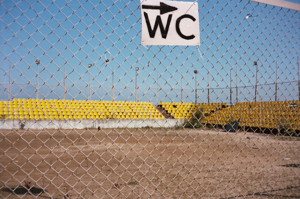 a sign on a chain link fence that says w c