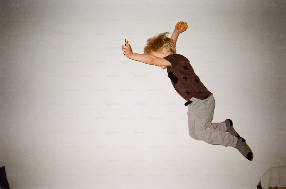 a young boy is jumping in the air with a frisbee