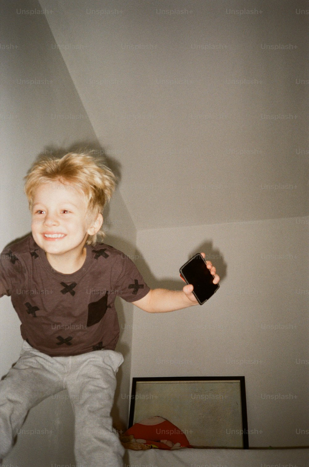 a young boy holding a remote control in his hand