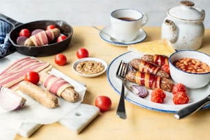 une assiette de nourriture avec du bacon, des haricots, des tomates et du pain