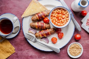 a white plate topped with food next to a cup of tea