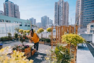 a woman standing on a roof with lots of plants