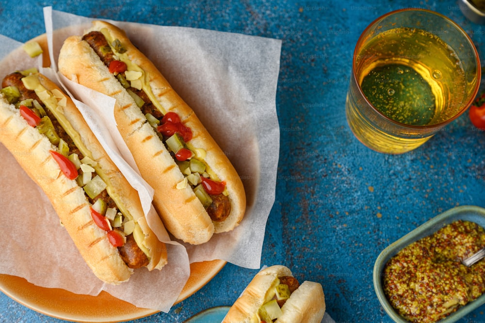 two hot dogs on buns with relish and mustard
