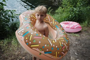 a young boy holding a giant inflatable donut