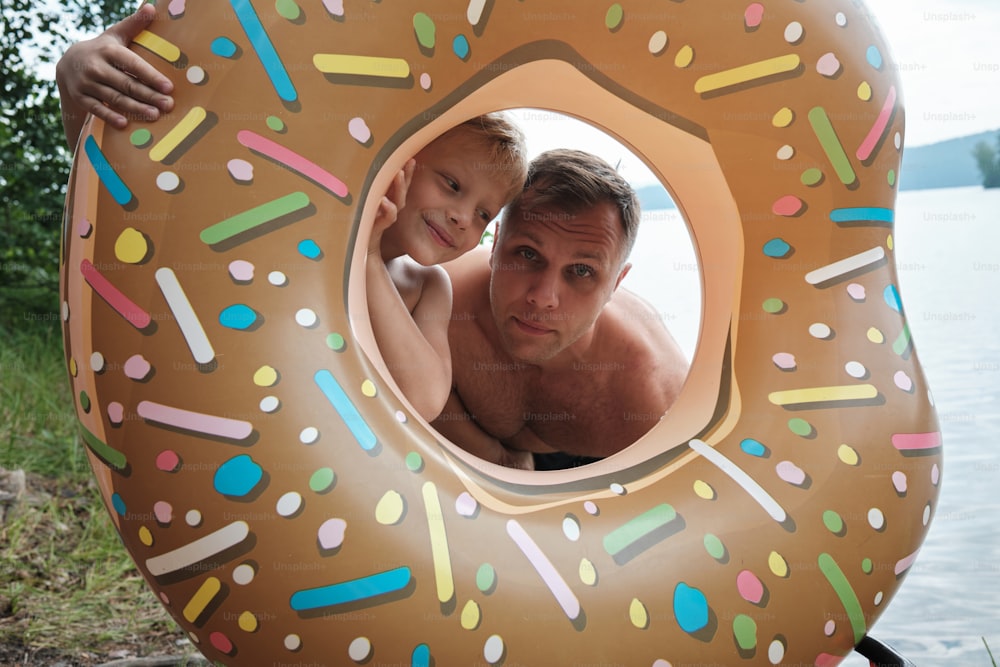 a man holding a child in a giant donut