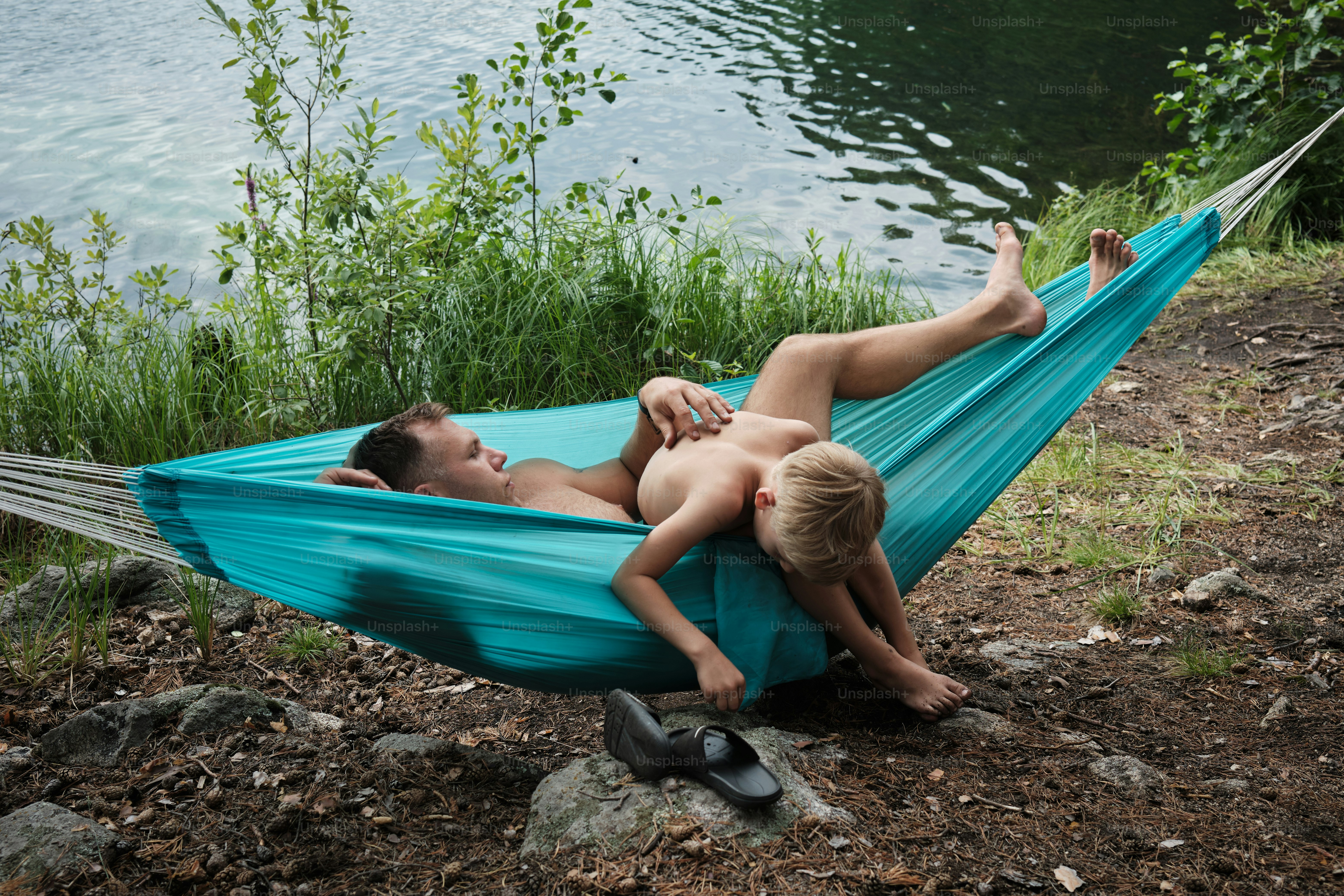 a man and a little boy laying in a hammock