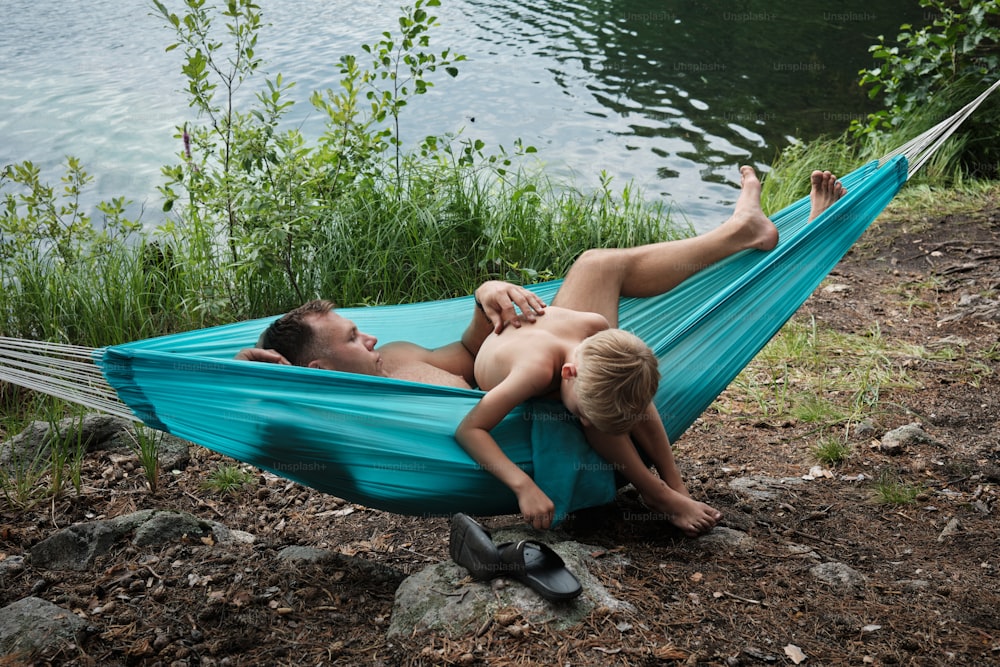 a man and a little boy laying in a hammock