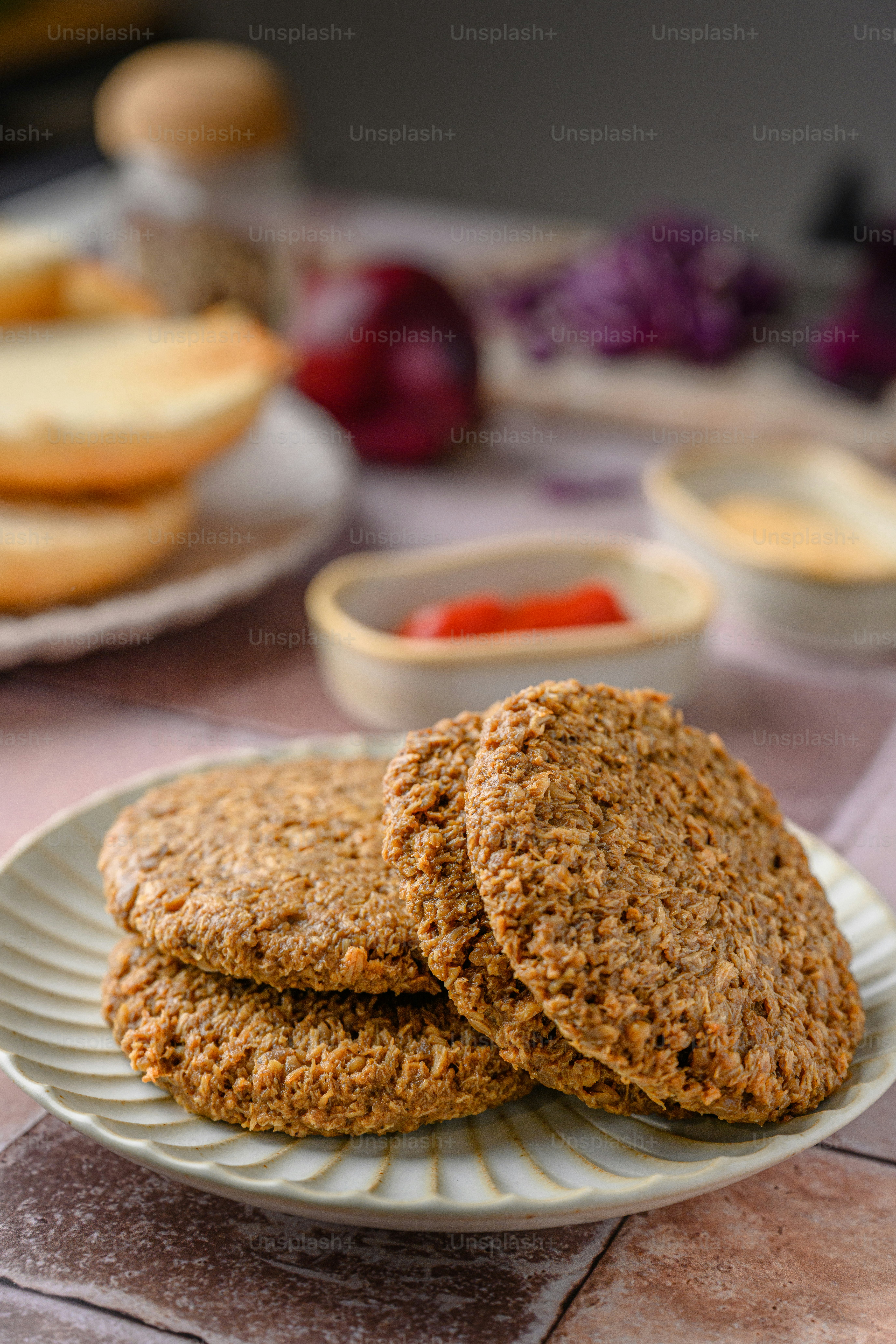 um prato branco coberto com biscoitos ao lado de uma tigela de frutas