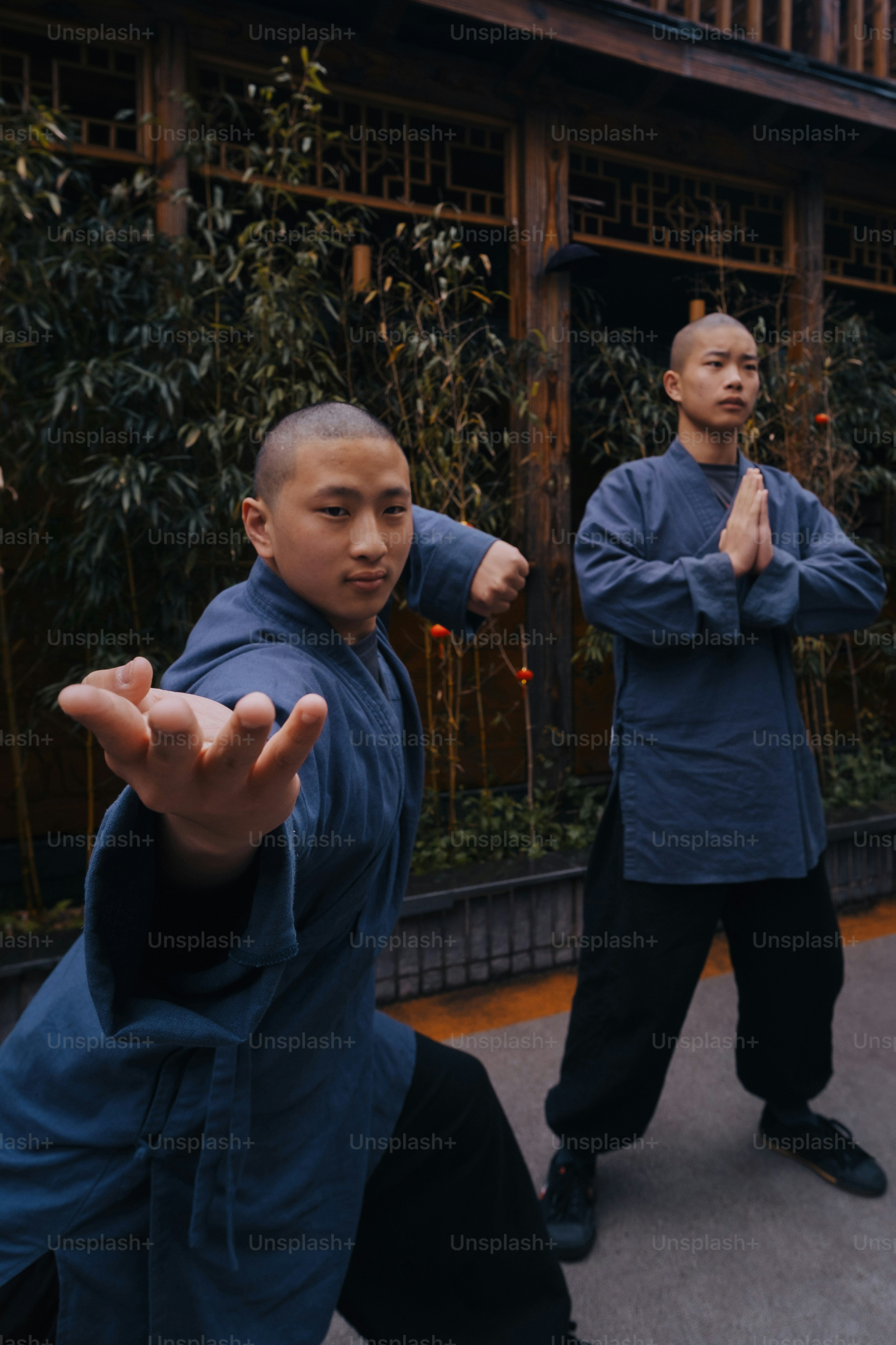 a couple of men standing next to each other in front of a building