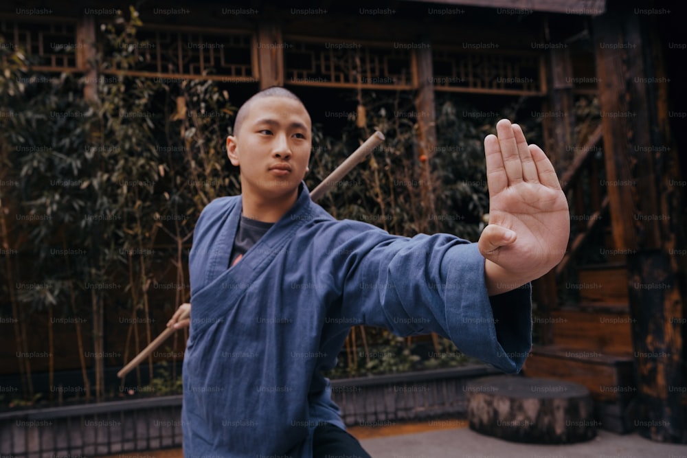 a man in a blue shirt is holding a stick