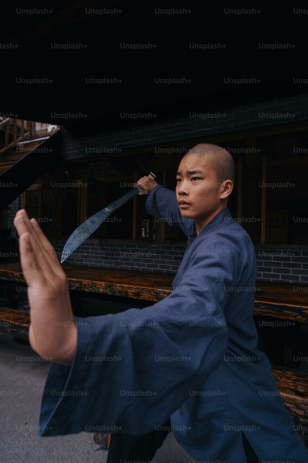 Ein Mann in einem blauen Kimono mit einem Messer in der Hand