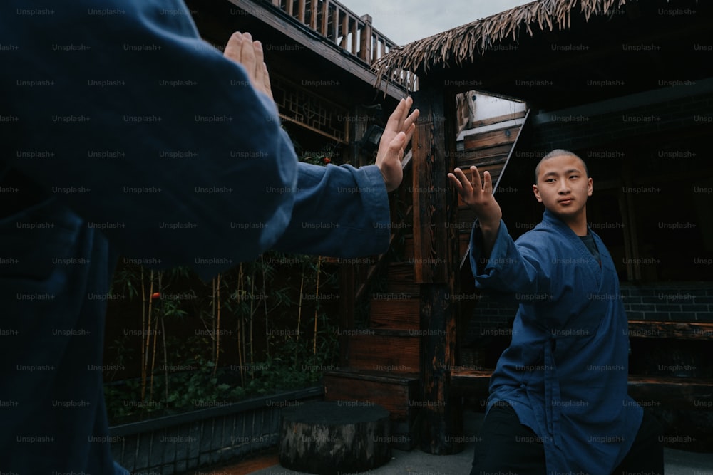 a man in a blue shirt holding his hands up