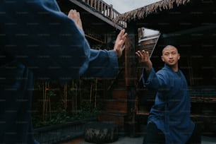 a man in a blue shirt holding his hands up