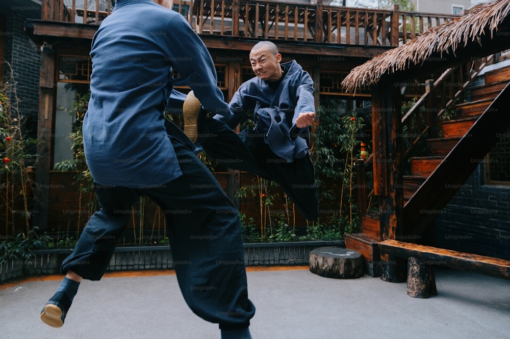 a man in a blue suit kicking another man in a blue suit