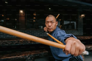 a man holding a baseball bat while sitting on a bench