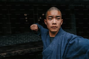 Un uomo in kimono blu posa per una foto