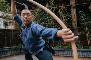 um homem segurando um arco e flecha de madeira