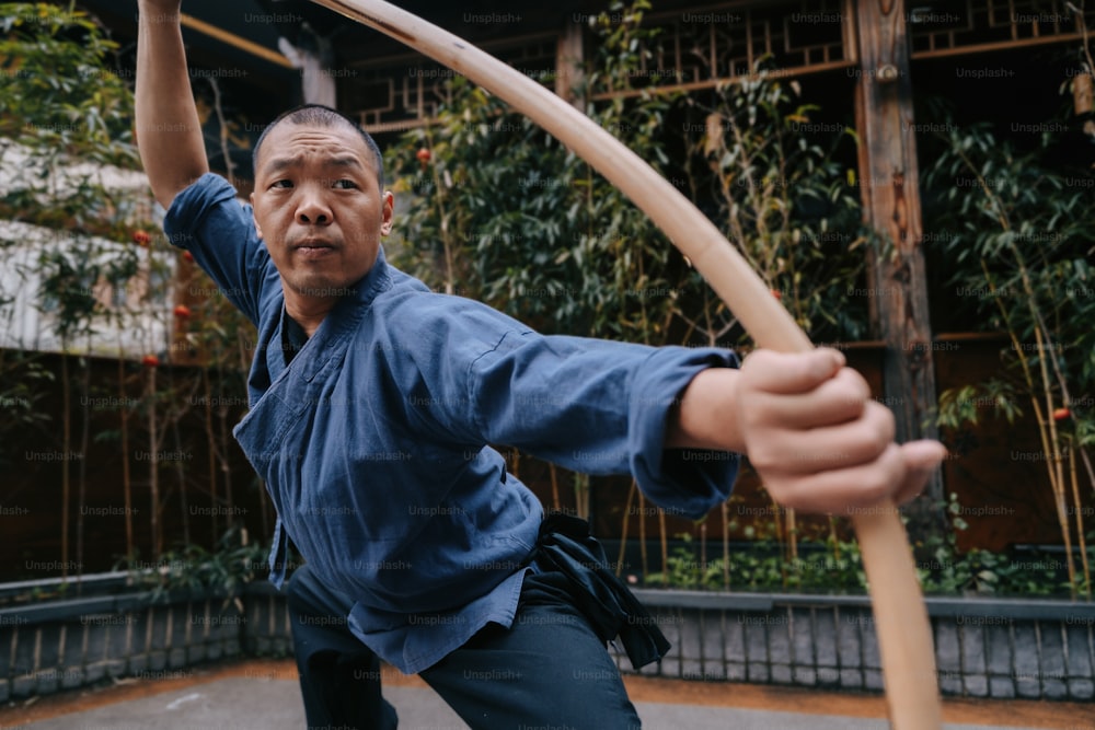 a man holding a wooden bow and arrow