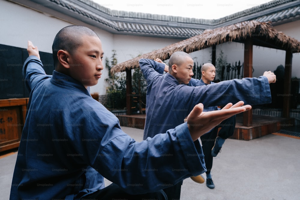 Eine Gruppe von Männern, die in einem Innenhof martialische Bewegungen üben
