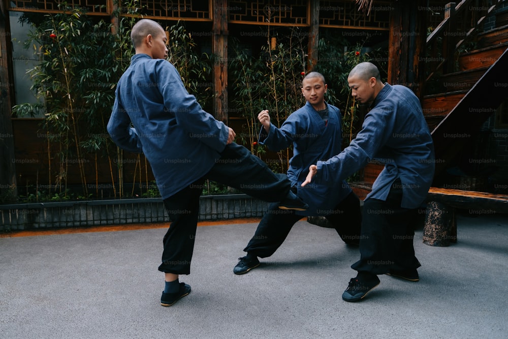 um grupo de homens praticando movimentos marciais em um pátio