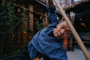 a man holding onto a pole in front of a building