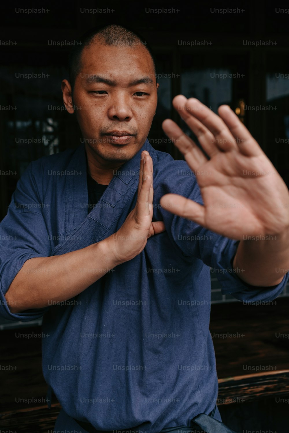 a man in a blue shirt holding his hands up
