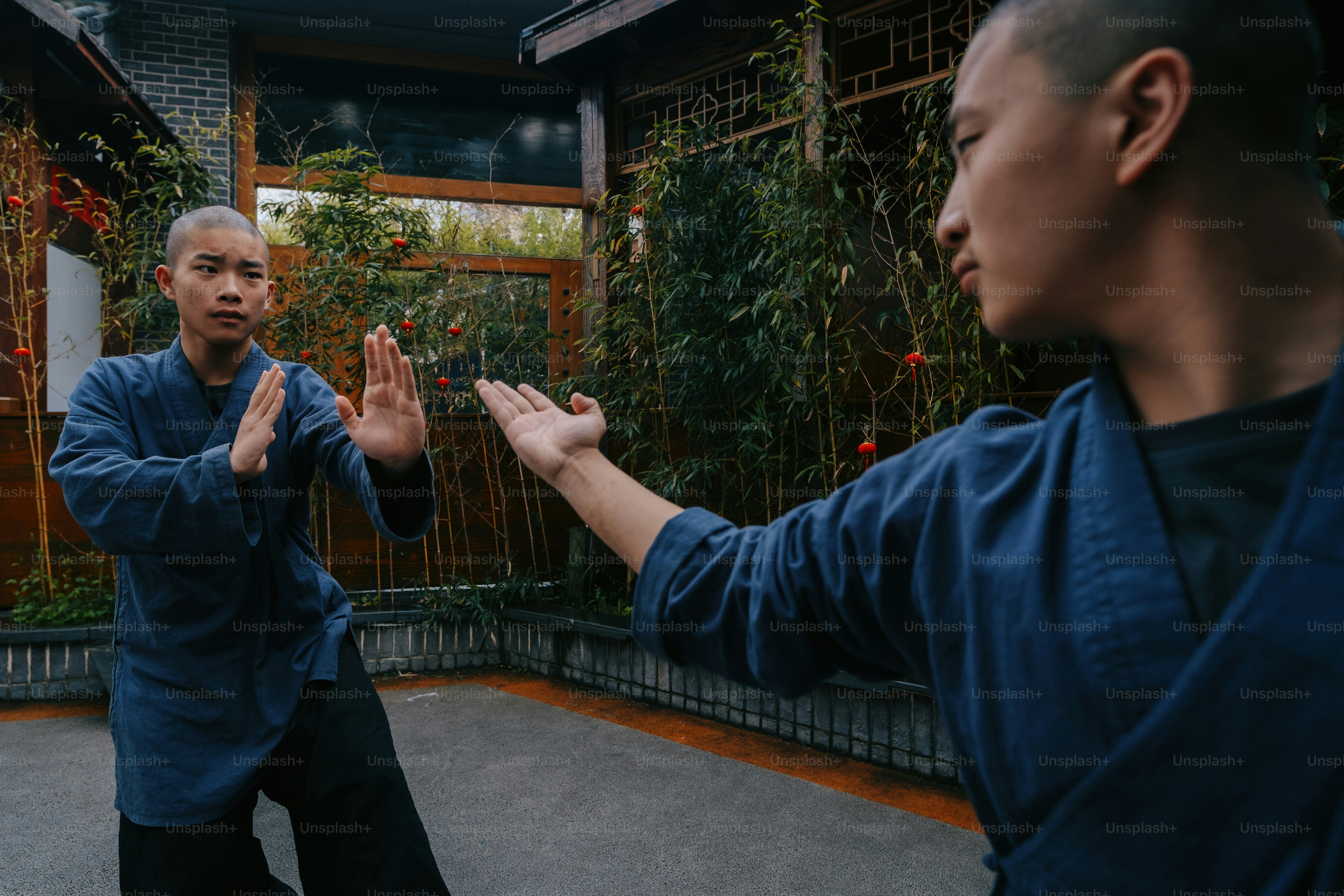 two men standing in front of a building with their hands in the air