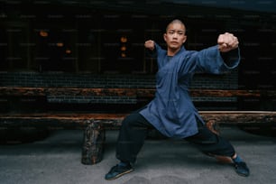Un hombre con una camisa azul está haciendo una pose de karate