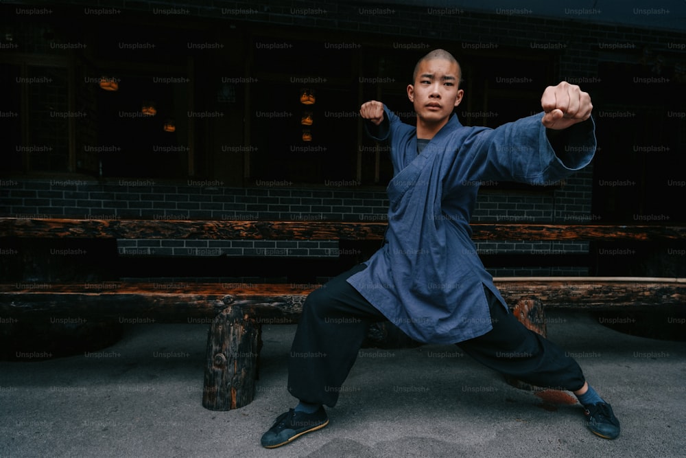Ein Mann in einem blauen Hemd macht eine Karate-Pose